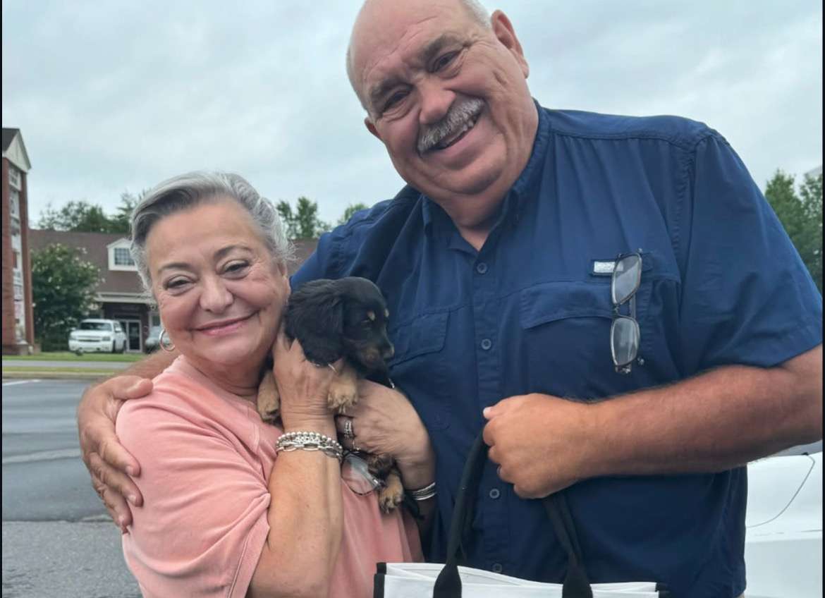 Happy family with their Dachshund puppy